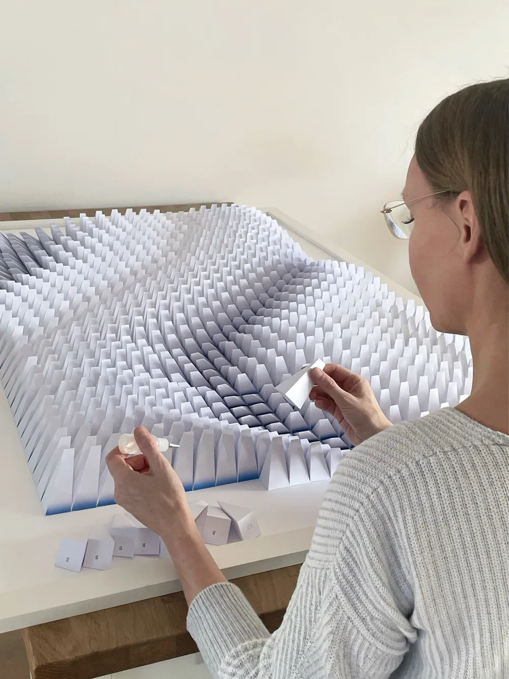 Larisa Semke setzt das Papierrelief Schicht für Schicht zusammen