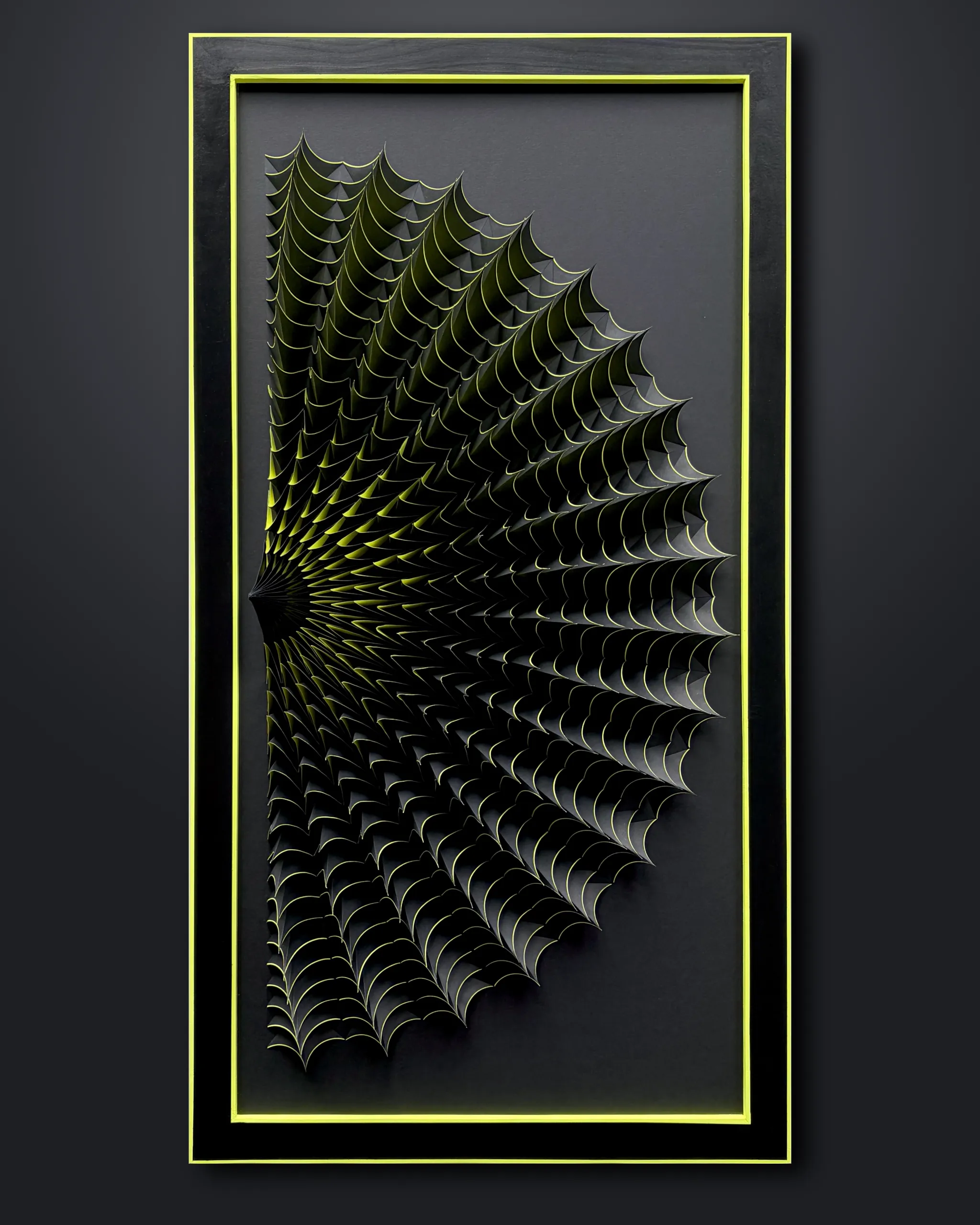 No. 23 – Expina – The work in its black frame with a neon yellow inner edge, the fan growing out of a spine at the left edge