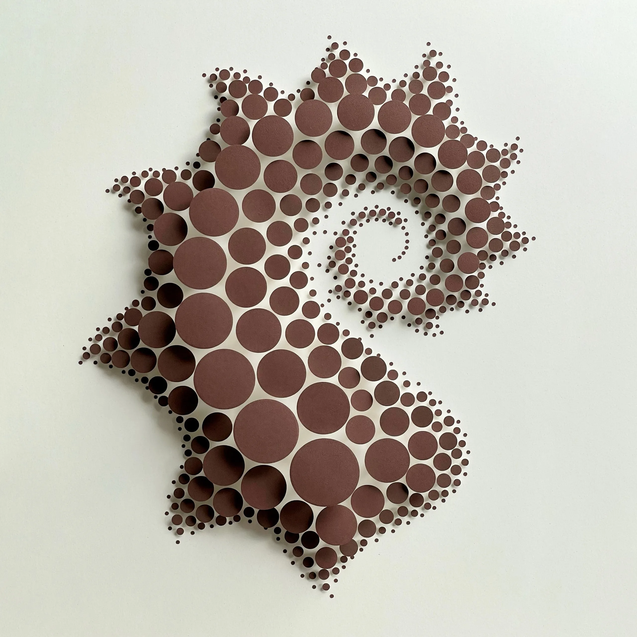 The whole work head-on, brown circles on white cones forming a jagged spiral on a pale ground