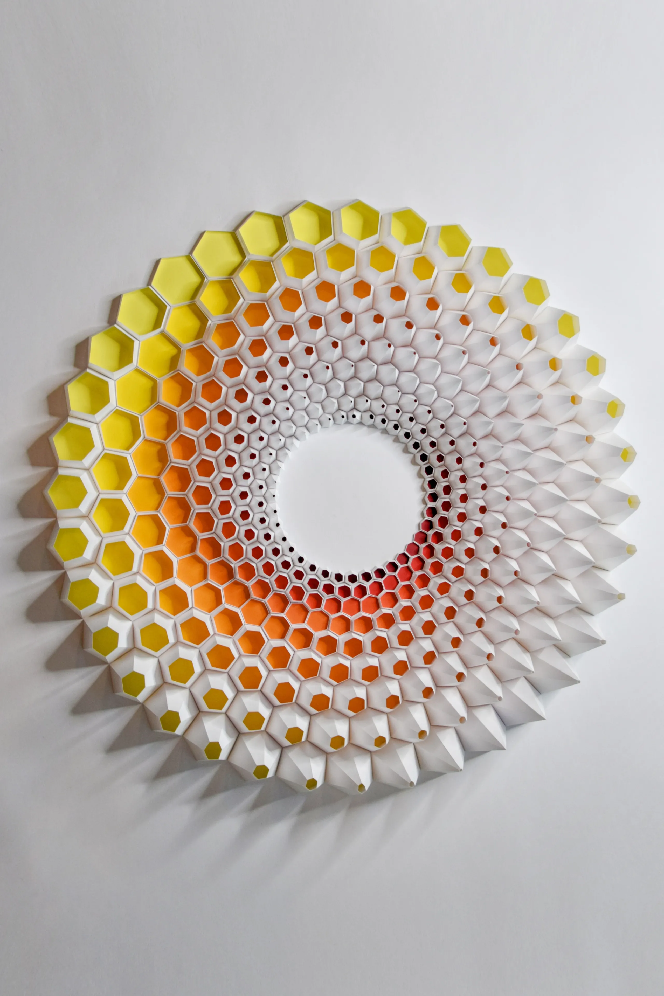 The round spiral of hexagonal cups, from yellow at the rim through orange to red at the white centre
