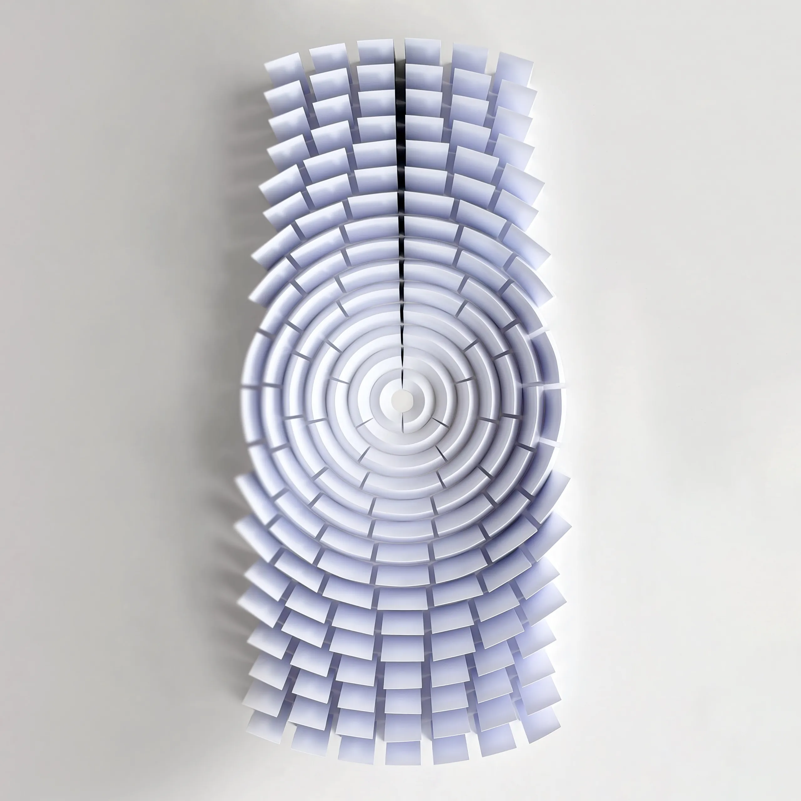 The whole work head-on, concentric rings of white paper segments growing flatter towards the centre
