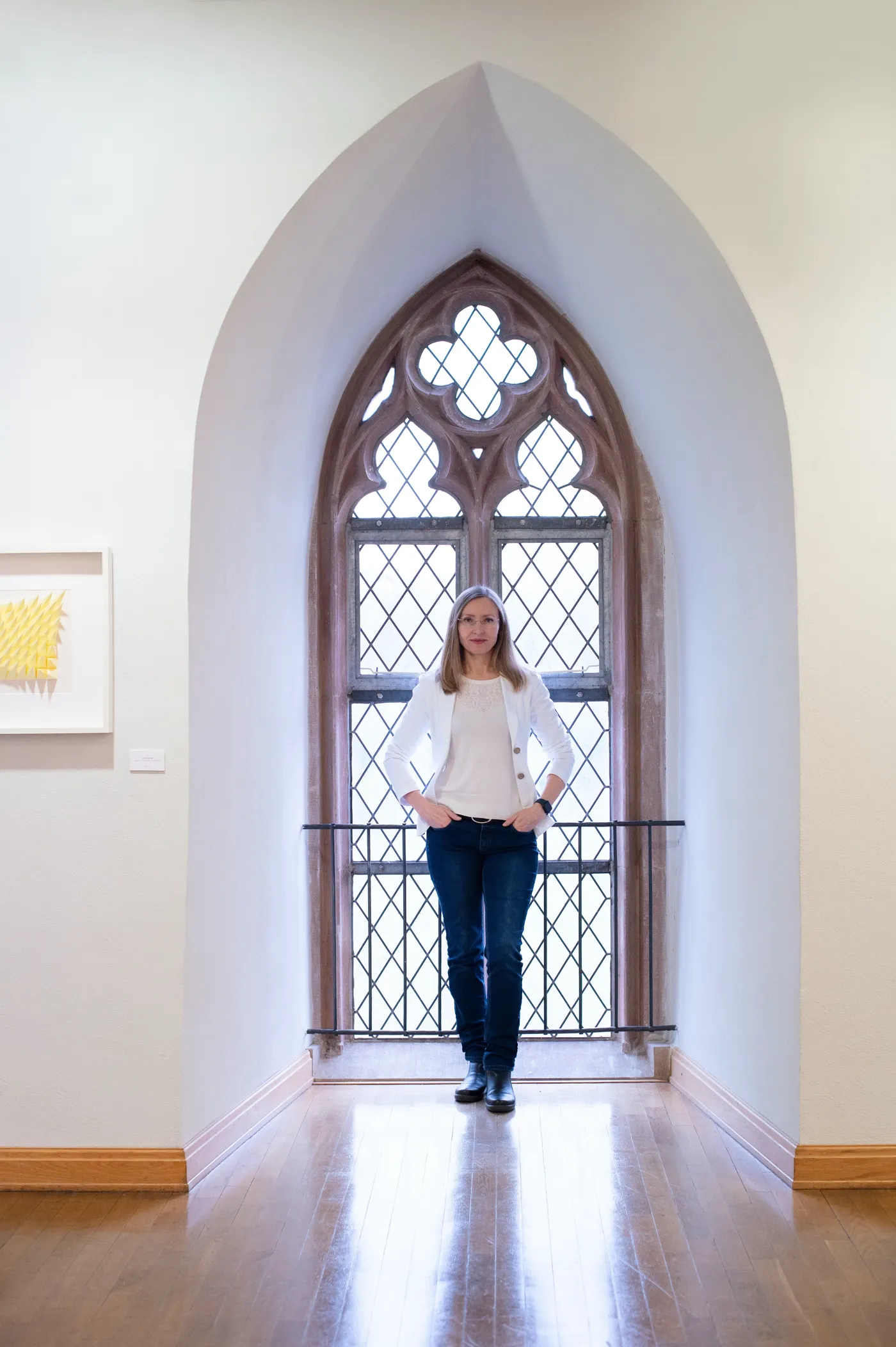 Larisa Semke in einer Galerie vor einem gotischen Spitzbogenfenster