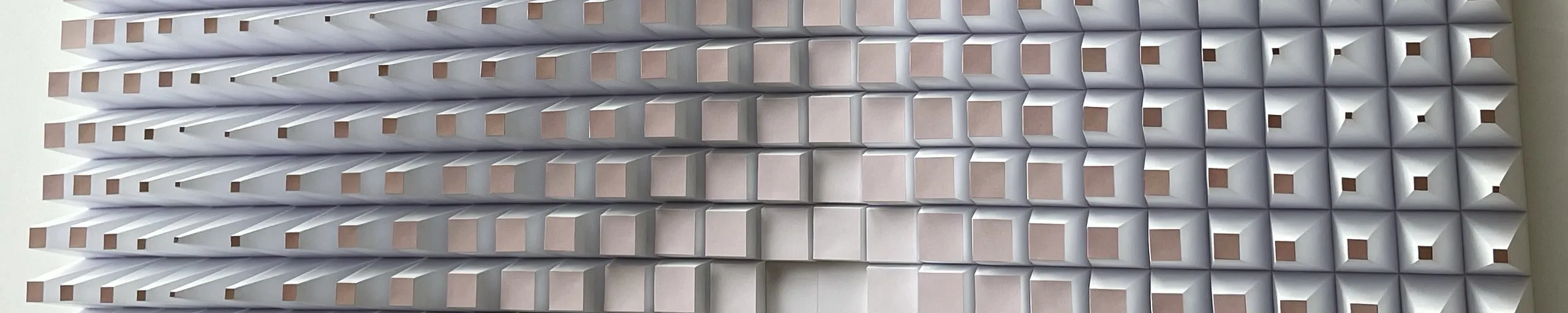 A steep angled view across the grid, the truncated pyramids opening forward into small dark squares